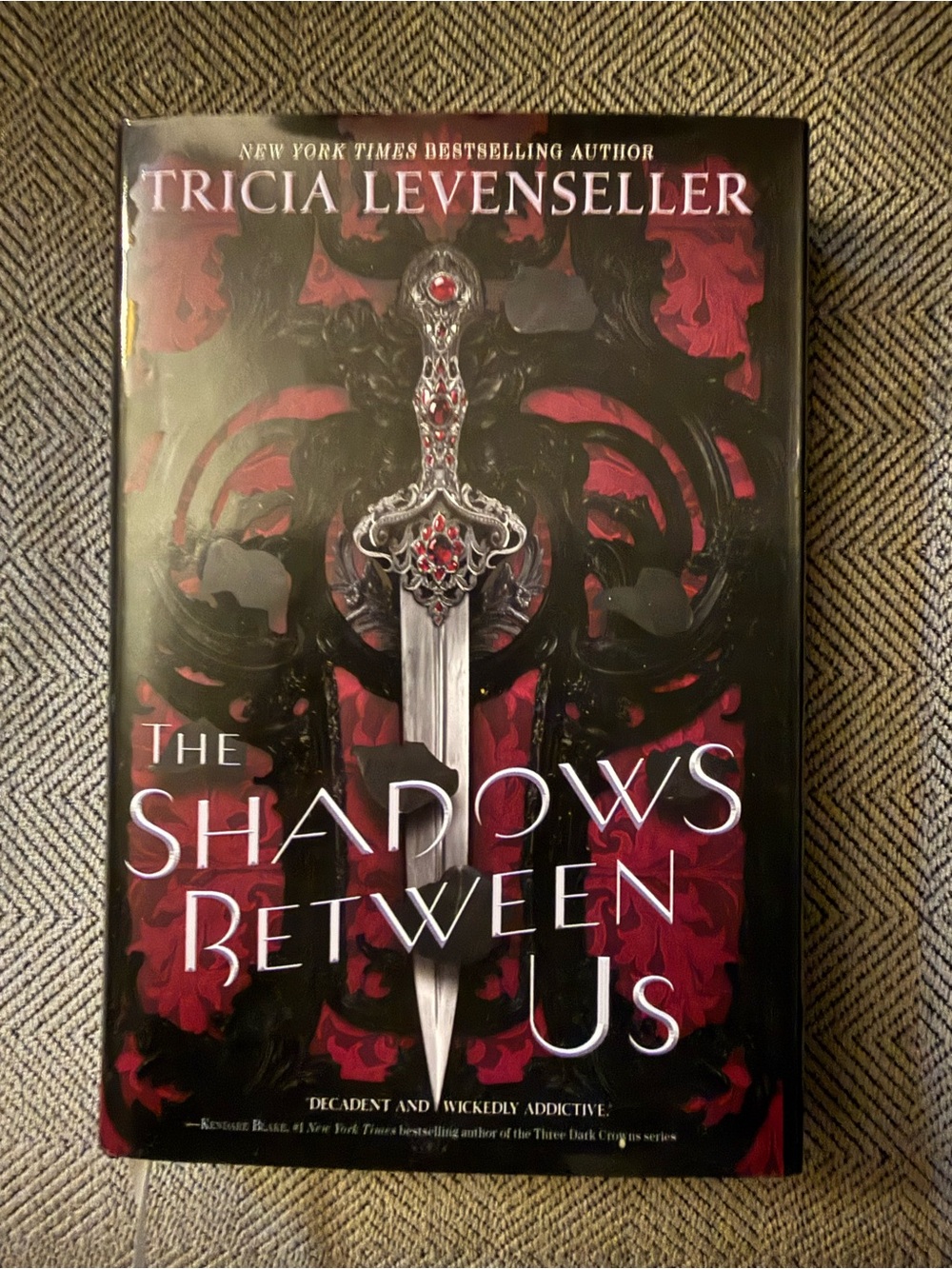 The Shadows Between Us by Tricia Levenseller - Red & Black Hardcover